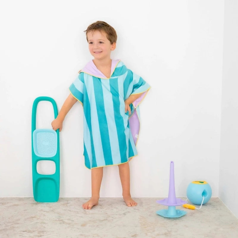 Toddler adjusting hooded poncho after swimming