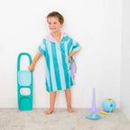 Toddler adjusting hooded poncho after swimming