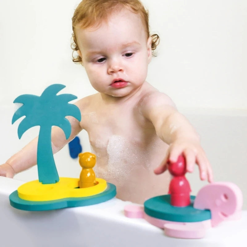 Toddler arranging foam islands and treasure chests in the bathtub