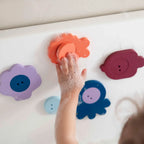 Toddler sticking Bath Puzzle Sea Side creatures to wet bathtub wall