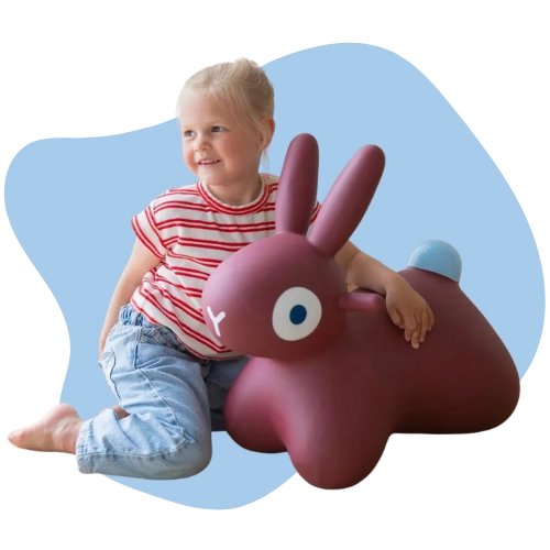 Toddler bouncing on a bunny ride-on toy to build balance and muscle strength